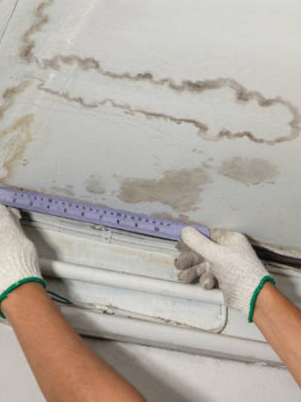 Worker fix leaking pipe in ceiling ,close-up of a stain on the ceiling.